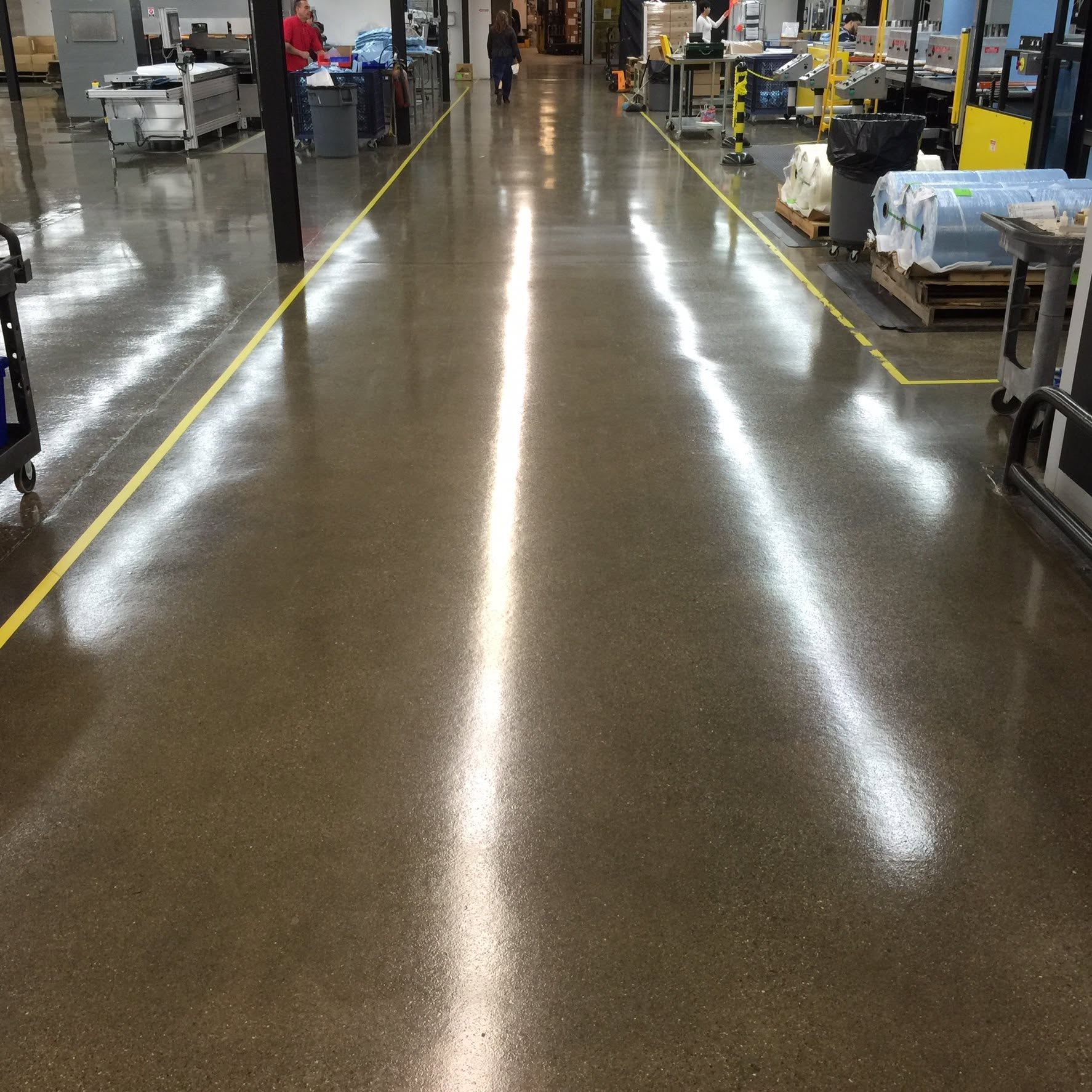 Polished concrete warehouse floor with visible aggregate and reflected lighting